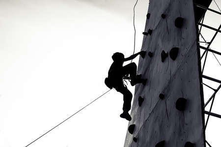 Free climber child young boy practicing on artificial boulders in gym, boulderingの写真素材