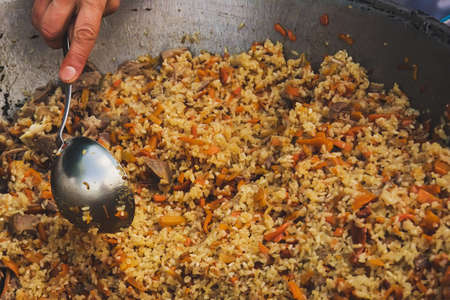 Ladle in kazane with Uzbek pilaf. Steamed rice with meat. The Asian kitchen. Middle Eastern ethnic food. national cuisine of Uzbekistanの写真素材