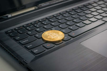 Photo Golden Bitcoins new virtual money Close-up with a computer keyboard. Electronic money mining conceptの写真素材