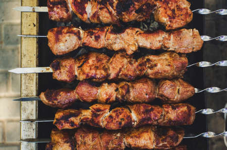 Appetizing fresh meat shish kebab prepared on a grill wood coal. Top view of cooking shashlikの写真素材