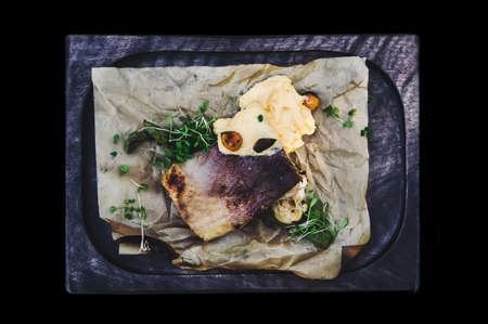 Salmon grilled with white mayonnaise sauce with greens, served on a kitchen Board. the view from the topの写真素材