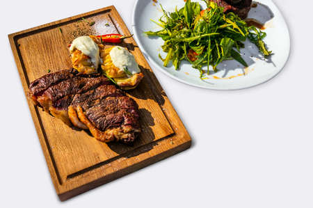 Grilled T-Bone Steak on cutting board on dark wooden on a white isolated backgroundの写真素材