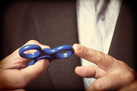 Businessman hand holding spinner and showing tricks, Relieving stress, popular fidget spinner. Antistress toyの写真素材