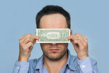 A man holds a U.S. 1 one dollar. The guy holds up a one dollar bill before my eyes. see through...
