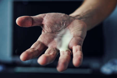 Man masturbate concept. finish sex. Drops of white liquid on the hand like semen, on the background of the TV in the room rented . Erotic online chatの写真素材