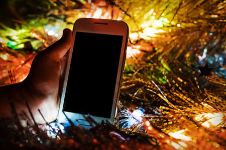 The child found a gift in the form of a white smartphone under the tree for the new year. Christmas...
