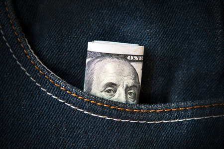 Benjamin Franklin peeking out of the pocket. one hundred dollars in pocket denim. American banknote in jeans. Pocket money. pocket expensesの写真素材
