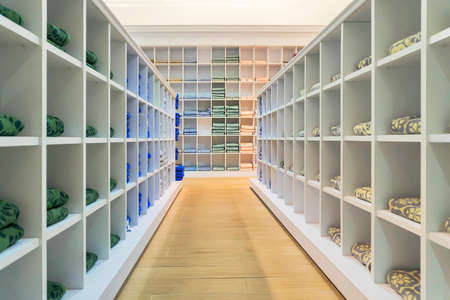 Colored terry towels on store shelves. A large towel rack. Clean towels assorted colors every day in a square white shelf.の写真素材