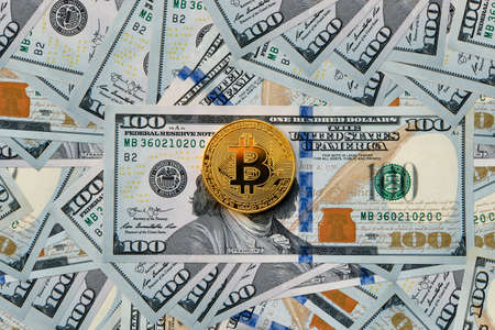 bitcoin and dollars. coin gold bitcoin hundred-dollar bills. Texture of pile of banknotes of American dollars. Earnings on the mining of cryptocurrencies. The increased rate of cryptocurrency.の写真素材