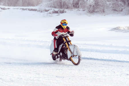 motorcycle on studded tires. Winter Speedway. Extreme bike race in winter. motorcycle on the ice of the frozen Lake Baikal. motorcyclist protective gear. Extreme dangerous fun in the winter outdoorsの写真素材