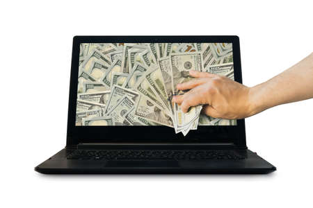Get money from online business holding US dollar in hand. business concept. hand pull money out of the laptop isolated on white background. earnings on the Internet. profit from Internet businessの写真素材