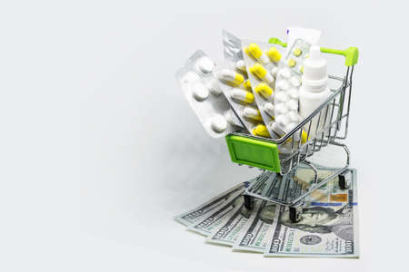Treatment and insurance are becoming more expensive. Prices for medicines are rising up. To buy pills is expensive. In Shopping cart for tablets, ointment, spray, drops and other medicationsの写真素材
