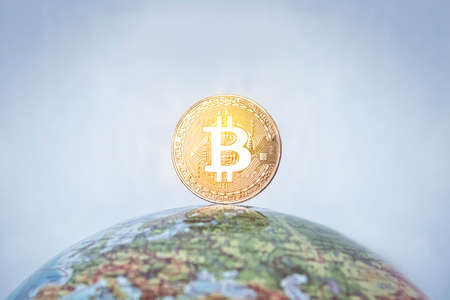 BITCOIN tag on the globe. gold bitcoin with gold bitcoin symbol and Earth. Bitcoin as a symbol world currency. globalization, globalize, worldwide, universal, global, international,の写真素材
