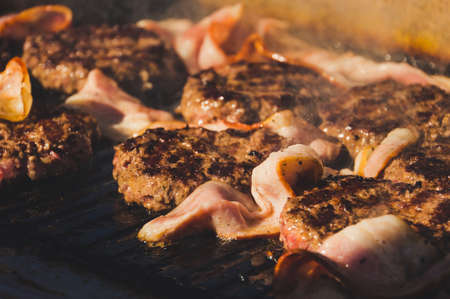 cutlet minced meat Burger fried and grilled bacon. Preparation of ingredients for a hamburger. Flaming grill and beef burgers. Meat hamburger Patty closeup.の写真素材