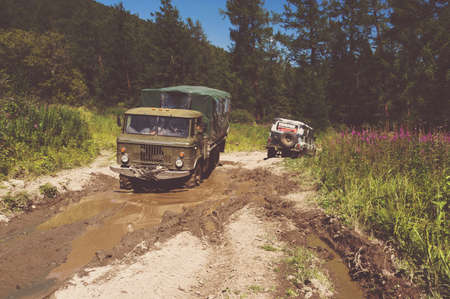 Heavy powerful truck-terrain vehi cle with off-road wheels. Big off-road truck pulls pross small...