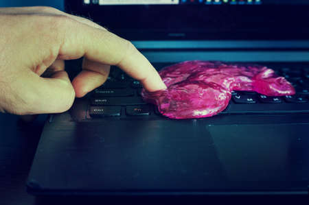 Red soft gel cleaning dust in hand. Cleaning your computer's keyboard.の写真素材