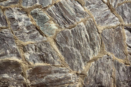 Texture of old rock wall for background. A wall of rough round stones instead of brick.