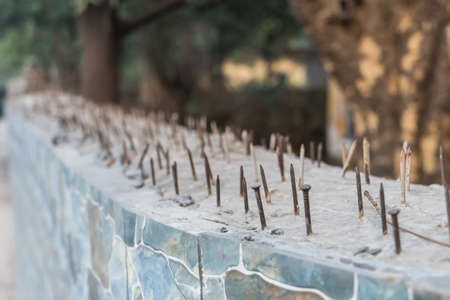 sharp nails of a Suite in a concrete fence for protection of the territory from illegal penetration of animals and thieves. system security and protection of private land against illegal entryの写真素材