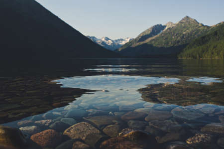 Beautiful mountain lake with turquoise Multinskoe. Clear water in the Altai Republic Siberia Russia. Evening mountain landscape with a lake with transparent water in the foregroundの写真素材