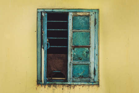 Open Old Window On yellow Wall. window with metal gratingの写真素材
