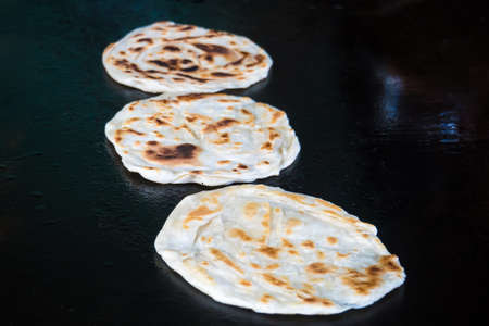Indian chapatti on fire, Pushkar, India Close up. Fried tortillas on a hot baking sheet. Street food. Naan.の写真素材