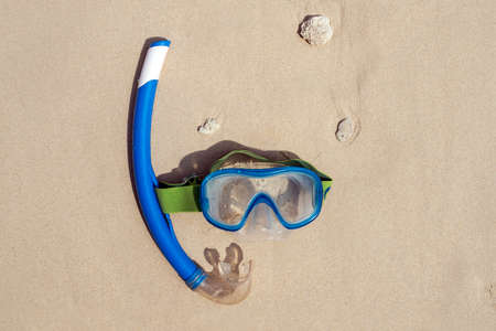 Colorful snorkel mask by the sea, remote tropical beaches. Travel and vacation concept. the view from the top. Blue classic snorkeling mask with blue plastic tube on white sandの写真素材
