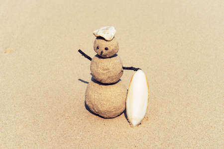 Sandman, doll from sand, snowman by the beach. joyful Sandman surfer with surfboard on sand.の写真素材