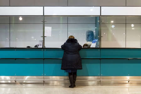 woman purchasing pass at front desk operated. verification at customs control.の写真素材