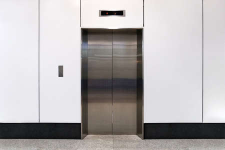 An empty modern elevator or lift with metal doors that are open in building with lighting.の写真素材