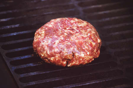 cooking burgers on hot grill. Big thick Patty of ground beef with on the grill. Raw Patty of fresh ground beefの写真素材