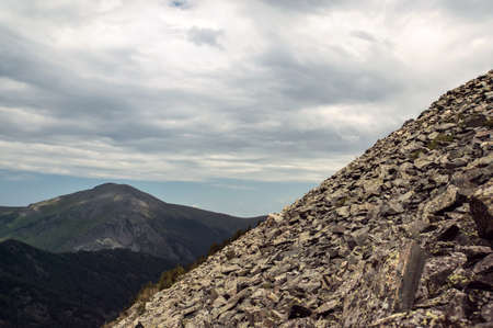 Mountain landscape. Stone deposits on the slopes of a steep mountain. Climbing a steep hillの写真素材