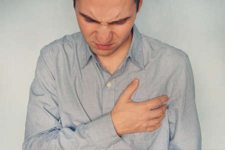 Man having heart ache holding hand on her chest Heart attack or stroke Health care concept. mental pain, mental sufferingの写真素材