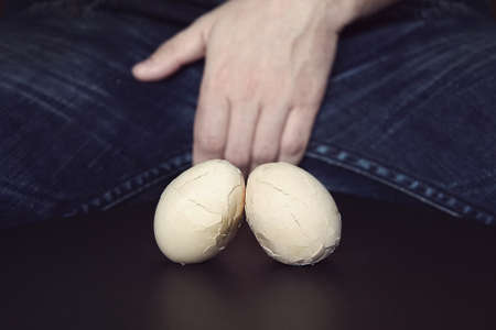 Men Testes - groin pain and lightning. The concept of disease in male testicles. Broken eggs are a symbol of problems with testicles in men.の写真素材