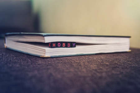 Love of books, reading. Stack of books in the colored cover lay on the table. Open book with curled leaves in the shape of a heart. Library, education. Empty space for Your text. inscription hobbyの写真素材