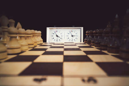 A stopwatch and a chessboard with a game in progress, The beginning of the chess game. the first moveの写真素材