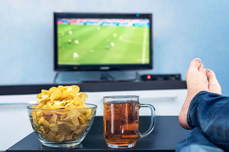 TV, television watching football match on TV with snacks and alcohol.