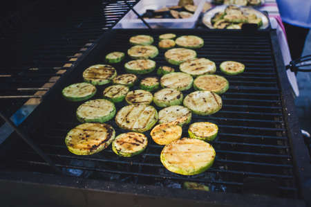 Grilled zucchini with addition of thyme, lemon zest and garlic. Zucchini cut into round pieces are fried on a large grill.の写真素材