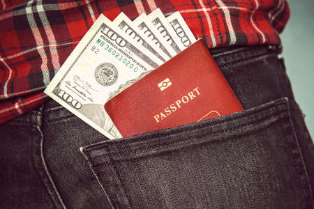 Passport in the back jeans pocket with American dollars. concept of travel. pocket money in my back...