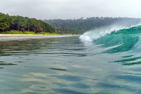 a big wave covers. Radhanagar Beach At Andaman and Nicobar Island, India. view from the sea. bursts...