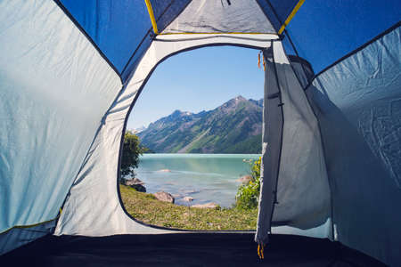 Camping tent with a beautiful view of a lake in Mountain lake Kucherlinskoe from above, Altay, Russia. Camping in the woodsの写真素材