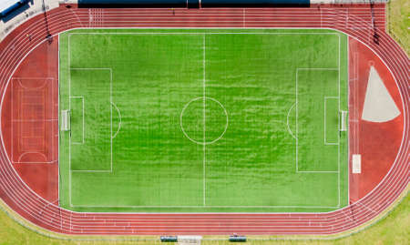 a real new soccer field, football field. Green grass. green striped lawn. White markings on the grass. running track for athleticsの写真素材