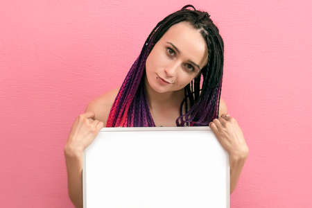 young sexy woman standing hold blank board, cover her breast, attractive naked girl hide empty board with copy space over pink background, studio shoot. writing Board markerの写真素材