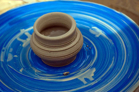 a clay pitcher on a Potter's wheel. The old craft of pottery makingの写真素材