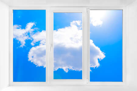 Clean window with an empty sill and blue sky. White plastic three-chambered three-sided boxの写真素材