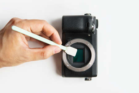 Close-up of camera matrix cleaning, technician pov. Photographer cleaning photocamera light sensor. Professional photographing equipment care, technology, hobby conceptの写真素材