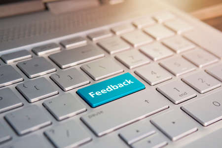 Feedback Computer keyboard with feedback button concept. Color button on the gray silver keyboard of modern ultrabook. caption on the buttonの写真素材