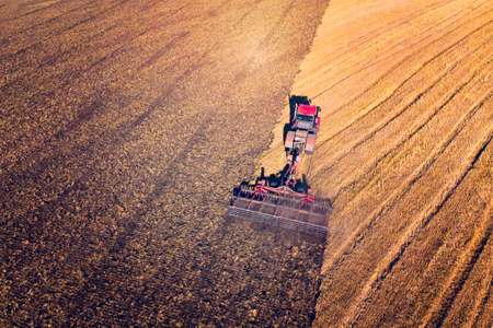 Agriculture machine harvesting crop in fields. Tractor pulls a mechanism for haymaking. Harvesting...