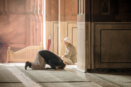 Religious muslim man praying inside the mosque. Two older Muslims at the great Friday Mosque Jami Masjid in New Delhi, India. 8 January 2018.のeditorial素材