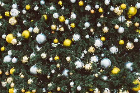 christmas tree decoration with toys, bubbles and pines. Gold and silver balls hanging on the green Christmas tree closeupの写真素材