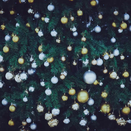 Christmas holiday background. Silver and gold bauble hanging from a decorated on tree.の写真素材
